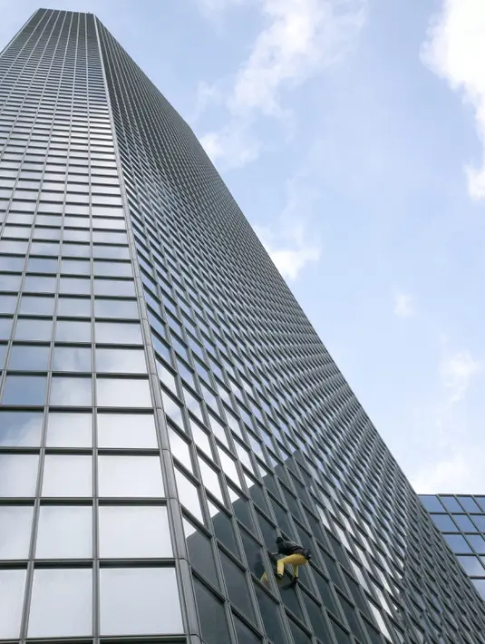 Aksi Alain Robert ketika memanjat gedung tanpa alat bantu di pusat bisnis La Defense, Paris, Prancis, Senin (21/3/2016). Pria yang dijuluki 'Spiderman' ini telah memanjat lebih dari 70 gedung tertinggi di dunia. (Jacques DEMARTHON/AFP)