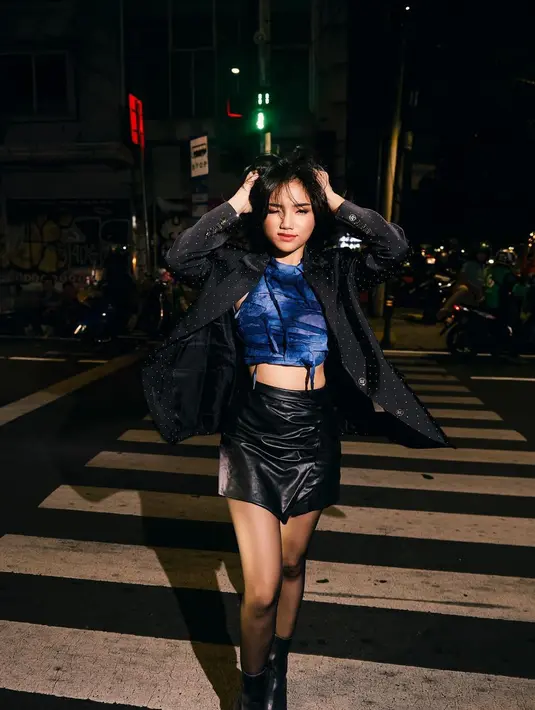 Berpose di jalanan bak mafia girl, Fuji tampil kece mengenakan atasan crop top sleeveless warna navy dengan motif abstrak. Atasan crop tersebut dipadukan dengan blazer oversize warna hitam dengan aksen manik-manik, mini skirt leather hitam, serta boots sebagai alas kaki.  [@aldosinarta].