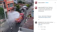 Petugas sedang melakukan penyemprotan disinfektan di Jalan Ablam, Makassar. (@agoez_bandz4)