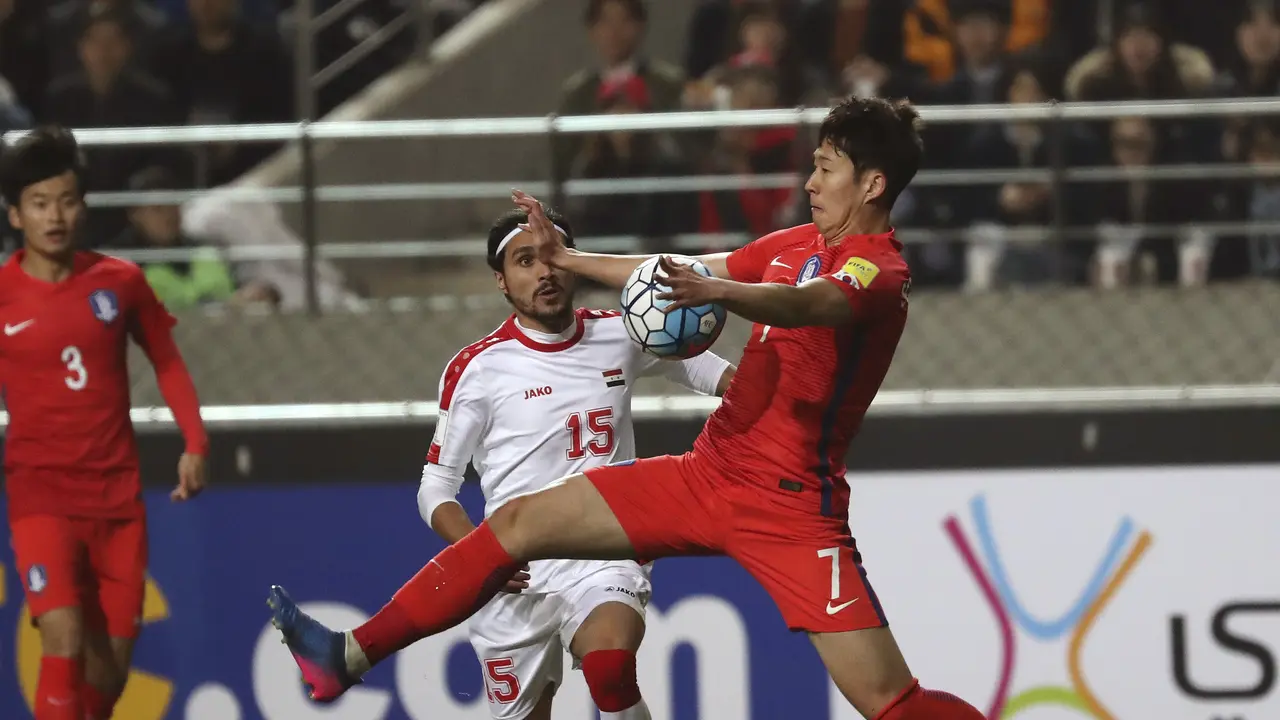 Bintang Timnas Korsel Son Heung-min (kanan) berebut bola dengan penggawa Suriah Alaa Al Shbbli pada laga kualifikasi Piala Dunia 2018 zona AFC di Seoul World Cup Stadium, Selasa (28//3/2017). 