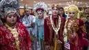 Sejumlah pasangan pengantin saat mengikuti nikah massal di Surabaya, Jawa Timur, Rabu (18/12/2019). Sebanyak 60 pasangan pengantin mengikuti nikah massal yang digelar Dinas Sosial Kota Surabaya. (JUNI KRISWANTO/AFP)