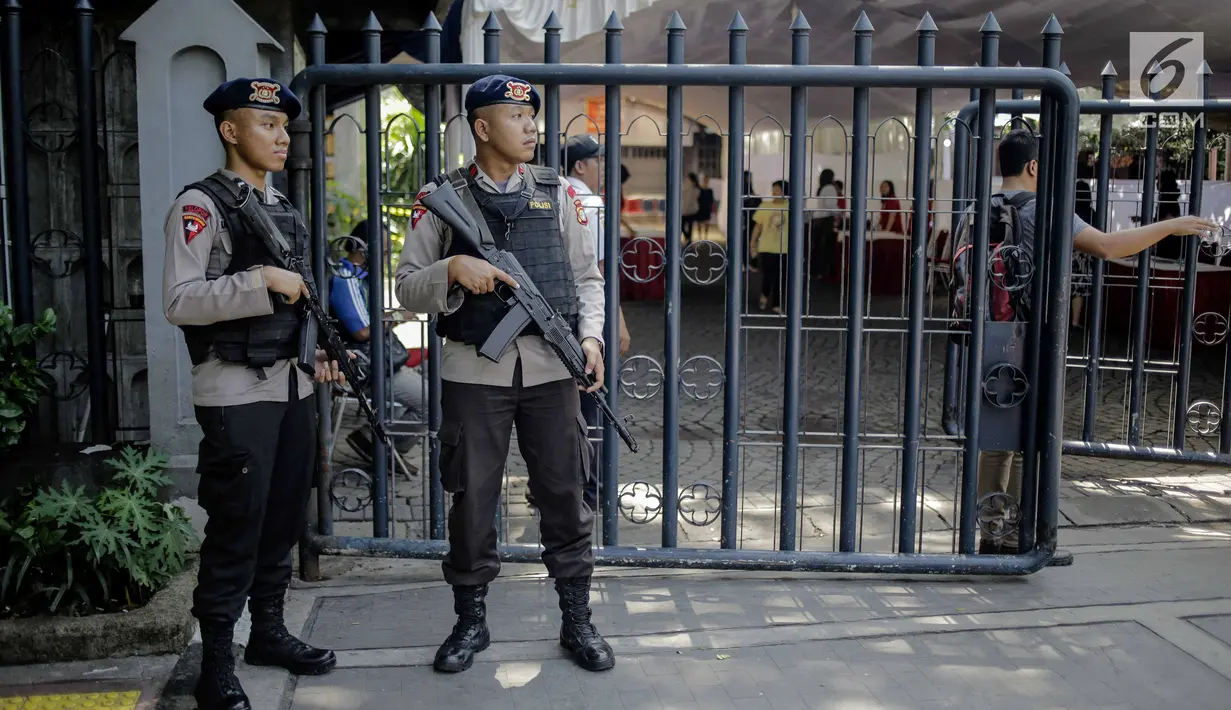 Polisi bersenjata lengkap berjaga di Gereja Katedral, Jakarta, Jumat (30/3). Penjagaan dilakukan untuk mengamankan misa Jumat Agung serta memberi kenyamanan kepada jemaat saat beribadah. (Liputan6.com/Faizal Fanani)