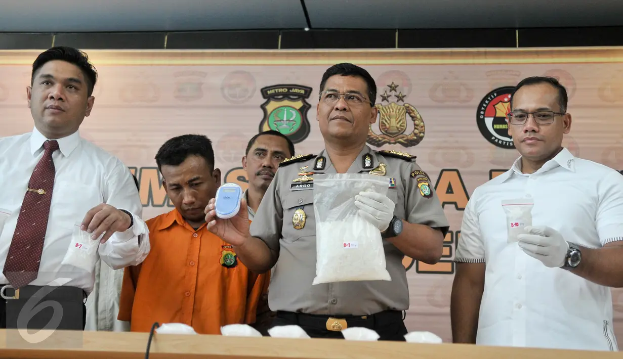 Petugas memperlihatkan barang bukti dan tersangka saat rilis di Polda Metro Jaya, Jakarta, Rabu (22/2). Dari tangan tersangka, Polisi berhasil mengamankan narkotika jenis sabu sebanyak 2,5kg. (Liputan6.com/Yoppy Renato)