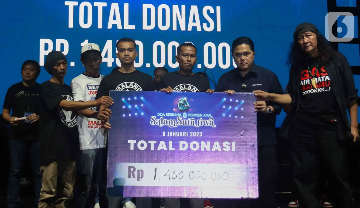 Menteri BUMM Erick Thohir memeberikan donasi secara simbolis secara kepada keluarga korban tragedi Kanjuruhan saat acara doa bersama dan konser amal Salam Satu Jiwa di Bekasi, Jawa Barat, Minggu (8/1/2023). Konser ini merupakan bentuk dukungan dan solidaritas terhadap korban tragedi Kanjuruhan Malang. (Liputan6.com/Herman Zakharia)
