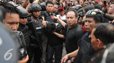 Petugas kepolisian menggiring salah satu tersangka perampokan disertai penyanderaan di Kawasan Pondok Indah, Jakarta, Minggu (3/9). Perampokan disertai penyanderaan terjadi sejak Minggu (3/9) pagi. (Liputan6.com/Helmi Fithriansyah)