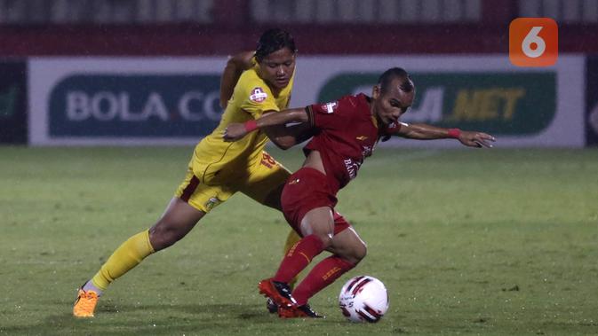 Gelandang Persija Jakarta, Riko Simanjuntak, berebut bola dengan gelandang Bhayangkara FC, Adam Alis, pada laga pekan ketiga Shopee Liga 1 2020, Sabtu (14/3/2020). Persija bermain imbang 2-2 atas Bhayangkara. (Bola.com/Yoppy Renato)