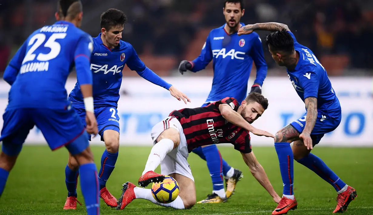 Striker AC Milan, Fabio Borini, berusaha melewati para pemain Bologna pada laga Serie A di Stadion San Siro, Senin (11/12/2017). AC Milan menang 2-1 atas Bologna. (AFP/Marco Bertorello)