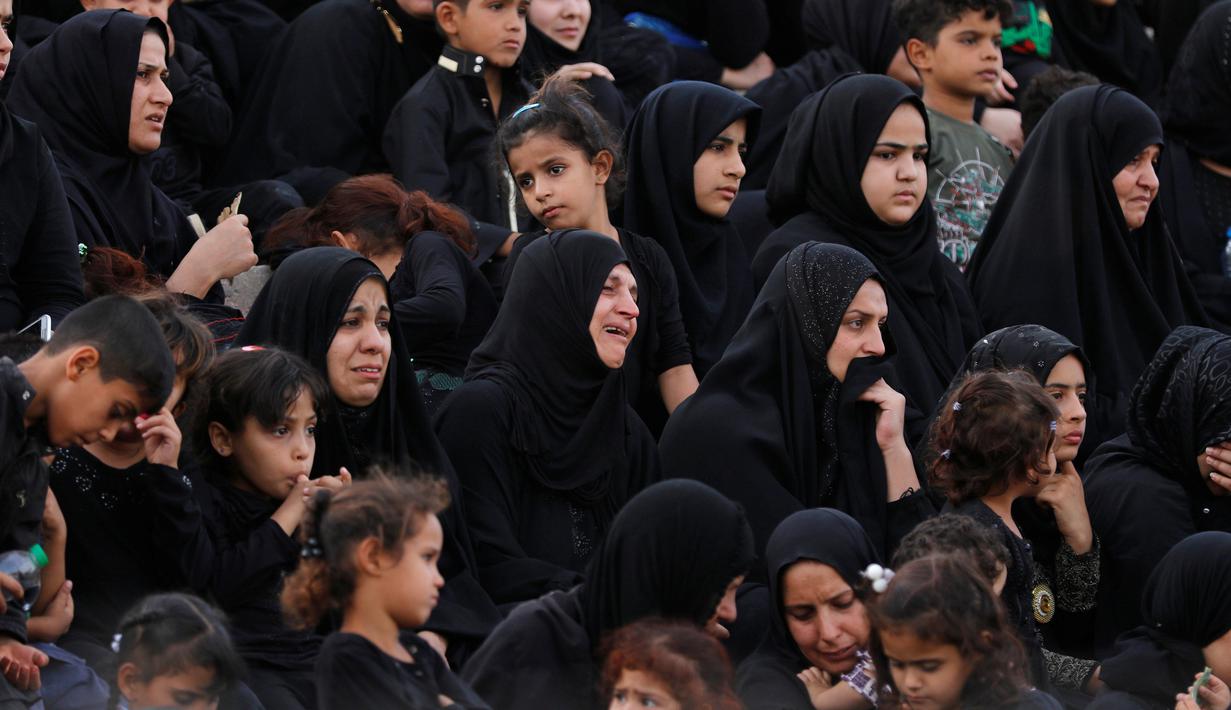 Sejumlah umat Syiah menahan tangis ketika menyaksikan reka ulang adegan Pertempuran Karbala yang menewaskan Husain bin Ali, di Sadr City, Baghdad, Irak, Rabu (12/10). Husain bin Ali merupakan cucu dari Nabi Muhammad. (REUTERS/Ahmed Saad)