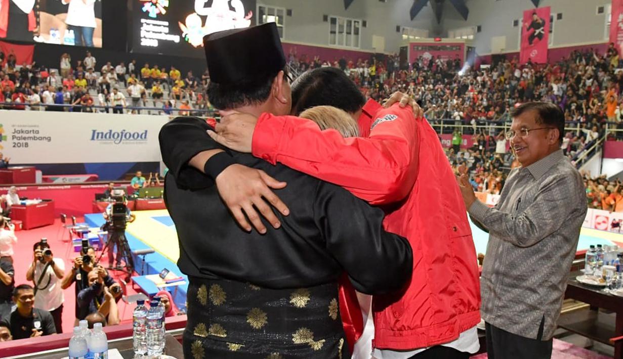 Presiden Joko Widodo atau Jokowi dan Ketua Umum Pengurus Besar Ikatan Pencak Silat Indonesia (IPSI) Prabowo Subianto memeluk atlet pencak silat peraih emas Asian Games 2018 Hanifan Yudani di Jakarta, Rabu (29/8). (Liputan6.com/HO/Biro Pers Setpres)