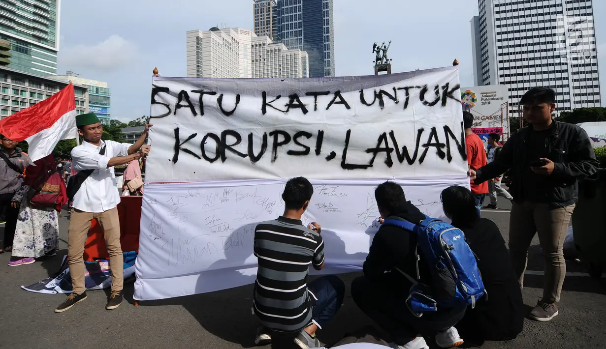 Aktivis mengajak warga menandatangani spanduk dukungan anti korupsi saat Hari Bebas Kendaraan di kawasan Bundaran HI, Jakarta, Minggu (10/12). Ajakan ini untuk memperingati Hari Antikorupsi 2017, 9 Desember. (Liputan6.com/Helmi Fithriansyah)