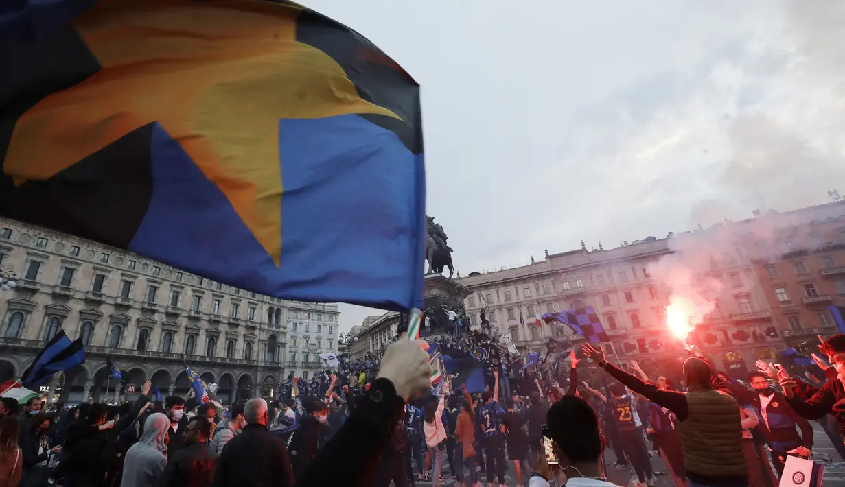 Suporter Inter Milan merayakan dan meneriakkan slogan-slogan di alun-alun Piazza Duomo di depan katedral gotik di Milan, Italia, Minggu (2/5/2021). Perolehan 84 poin, Inter Milan sudah tak dapat dikejar tim lain. (AP Photo/Luca Bruno)