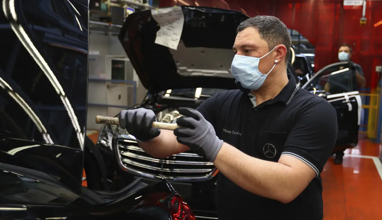Pekerja merakit mobil Mercedes-Benz S-class di pabrik Mercedes, Sindelfingen, Jerman, Kamis (30/4/2020). Mulai 27 April 2020, Mercedes-Benz kembali membuka jalur produksi yang sebelumnya ditutup karena pandemi virus corona COVID-19. (AP Photo/Matthias Schrader)