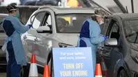 Staf mengumpulkan sampel di klinik pengujian COVID-19 drive-thru di Pantai Bondi di Sydney, Sabtu (8/1/2022). Negara bagian terpadat di Australia itu memberlakukan kembali beberapa pembatasan dan menangguhkan operasi elektif ketika kasus COVID-19 melonjak ke rekor baru lainnya. (AP Photo/Mark Baker)