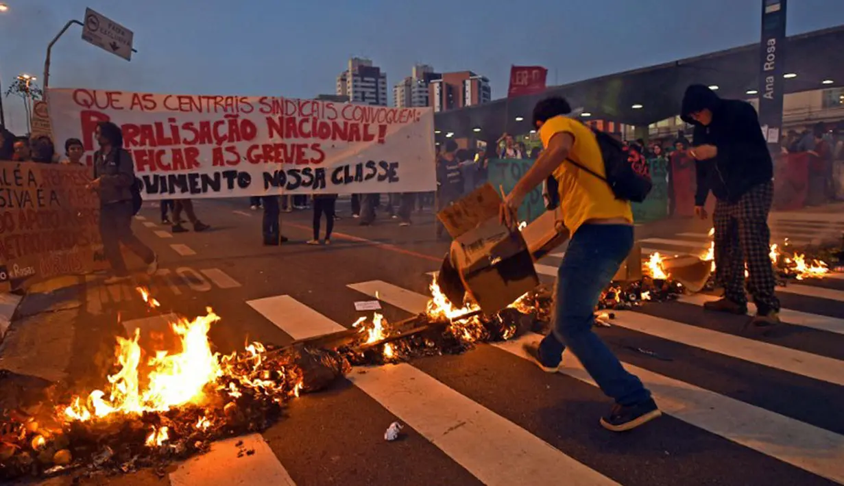 Dalam aksinya, pekerja kereta bawah tanah dan anggota MTST (Gerakan Pekerja Tunawisma) Brasil memblokade jalan dengan membakar beberapa atribut, Sao Polo, (9/6/2014). (AFP PHOTO/NELSON Almeida)