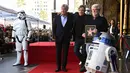 Pemeran Luke Skywalker dalam film "Star Wars", Mark Hamill berpose dengan karakter droid R2-D2 saat upacara pemberian Hollywood Walk of Fame di Los Angeles (8/3). (Jordan Strauss / Invision / AP)