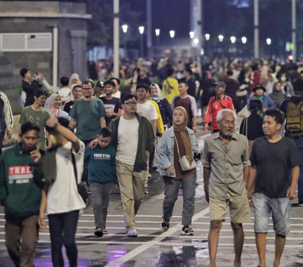 Ribuan warga berdatangan saat memadati "Malam Muda Mudi' yang digelar di kawasan Bundaran HI, Jakarta, Minggu (31/12/2023). <br>