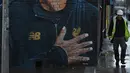 Seorang pekerja melintas dekat mural pelatih klub Liverpool, Jurgen Klopp di Jamaica Street, pusat kota Baltic Triangle di Liverpool, Senin (10/12). Pengerjaan mural itu dimulai sejak 8 November 2018 lalu oleh seniman jalanan "Akse". (Paul ELLIS / AFP)