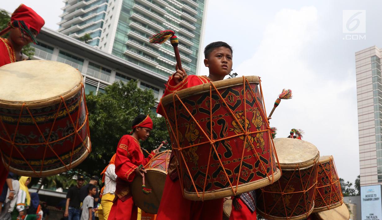 Seniman cilik memainkan alat musik tambur khas Minangkabau saat car free day (CFD) di Jakarta, Minggu (13/1). Pertunjukan tersebut untuk mengenalkan alat musik tradisional Nusantara kepada masyarakat. (Liputan6.com/Angga Yuniar)