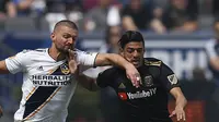 Pemain Los Angeles FC, Carlos Vela (kanan) berebut bola dengan pemain Los Angeles Galaxy, Perry Kitchen pada laga Major League Socccer di StubHub Center,  California, (31/3/2018). LA Galaxy menang 4-3. (AP/Jae C. Hong)