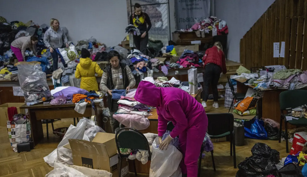 Kesibukan relawan Ukraina saat menyortir pakaian yang disumbangkan untuk kemudian didistribusikan ke penduduk setempat di Lviv, Ukraina barat, pada Rabu (2/3/2022). Invasi Rusia ke Ukraina telah memasuki hari keenam. (AP Photo/Bernat Armangue)