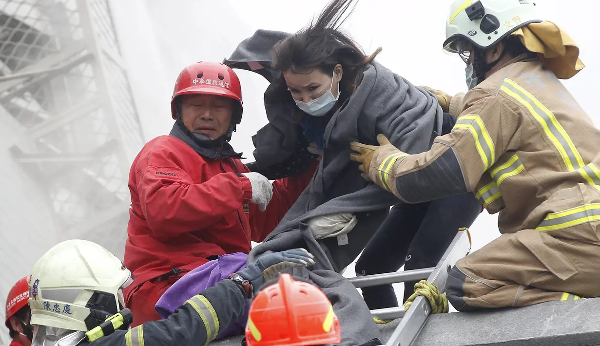 Petugas penyelamat mengevakuasi seorang korban di gedung apertemen yang runtuh akibat gempa 6,4 SR  di Tainan, (6/2). Menurut data meteorologi gempa terjadi pada kedalaman 16,7 kilometer di bawah permukaan laut. (REUTERS/Stringer)