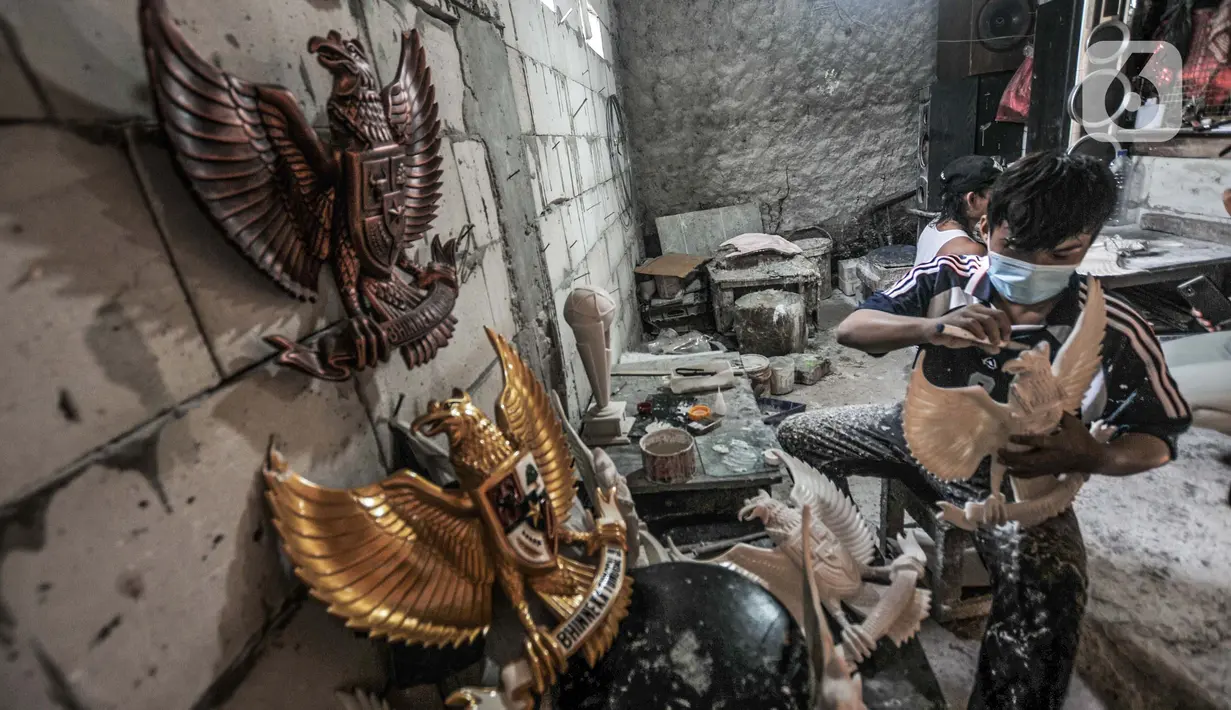 Perajin saat menyelesaikan pembuatan patung Garuda Pancasila di industri rumahan kawasan Bali Raya, Kalimalang, Jakarta Timur, Selasa (1/7/2021). Usaha ini kembali bangkit di masa pandemi Covid-19 seiring datangnya pesanan dari sejumlah wilayah di Indonesia. (merdeka.com/Iqbal S. Nugroho)