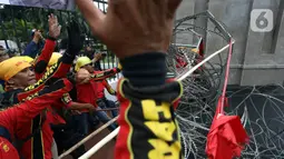 Aksi unjuk rasa yang digelar oleh massa gabungan di depan Gedung DPR, Senayan, Jakarta, Selasa (14/3/2023). Adapun keberadaan massa buruh yang berdemodengan mengenakan baju bewarna merah itu mengakibatkan kemacetan di wilayah sekitar gedung DPR RI. (Liputan6.com/Johan Tallo)