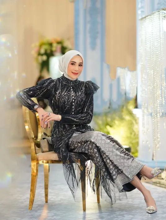 <p>Outfit kondangan yang tak kalah luar biasa dari Erin. Ia mengenakan atasan dengan siluet dramatis berwarna hitam dengan tambahan nuansa emas, dipadu dengan kain batik dari bahan satin sebagai rok panjang. Foto: Instagram.</p>