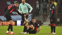 Pemain Liverpool James Milner (tengah) mendapat bantuan untuk berdiri dari rekannya Jordan Henderson saat melawan Aston Villa pada pertandingan putaran ketiga Piala FA di Stadion Villa Park, Birmingham, Inggris, Jumat (8/1/2021). Liverpool menang 4-1. (AP Photo/Rui Vieira)