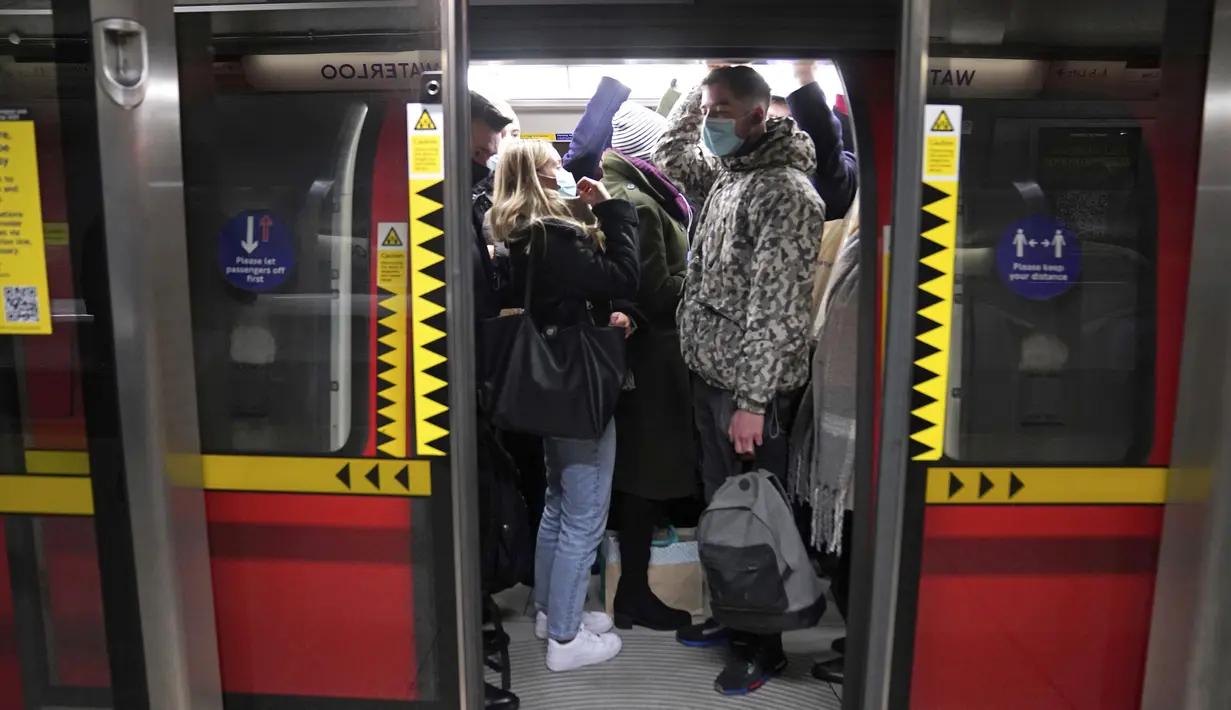 Para komuter berdesakan di gerbong kereta Jubilee, di stasiun bawah tanah Waterloo saat mereka bekerja menuju kantor di London, Kamis (20/1/2022). Pemerintah Inggris mengakhiri pembatasan COVID-19, termasuk mandat masker, bekerja dari rumah dan paspor vaksin mulai Kamis. (Stefan Rousseau/PA via AP)