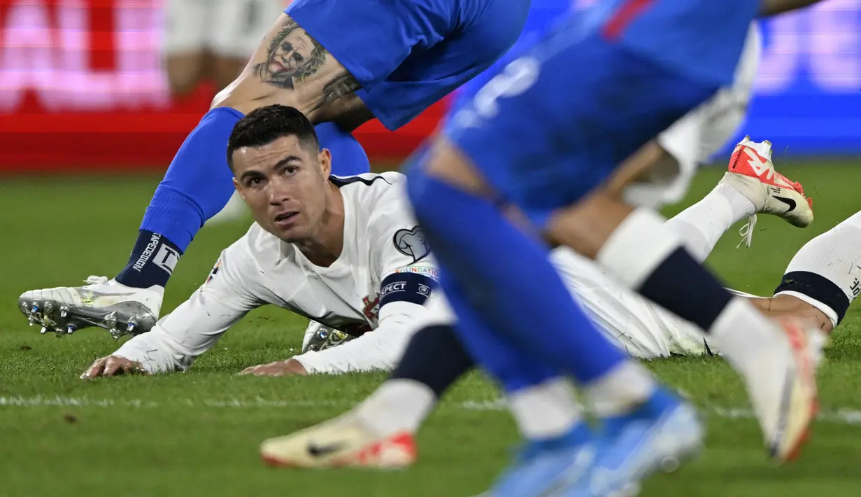 Striker Timnas Portugal, Cristiano Ronaldo terjatuh saat menghadapi Slovakia pada laga Grup J kualifikasi Euro 2024 di National Football Stadium, Bratislava, Slovakia, Sabtu (9/9/2023) dini hari WIB. (AP Photo/Radovan Stoklasa)