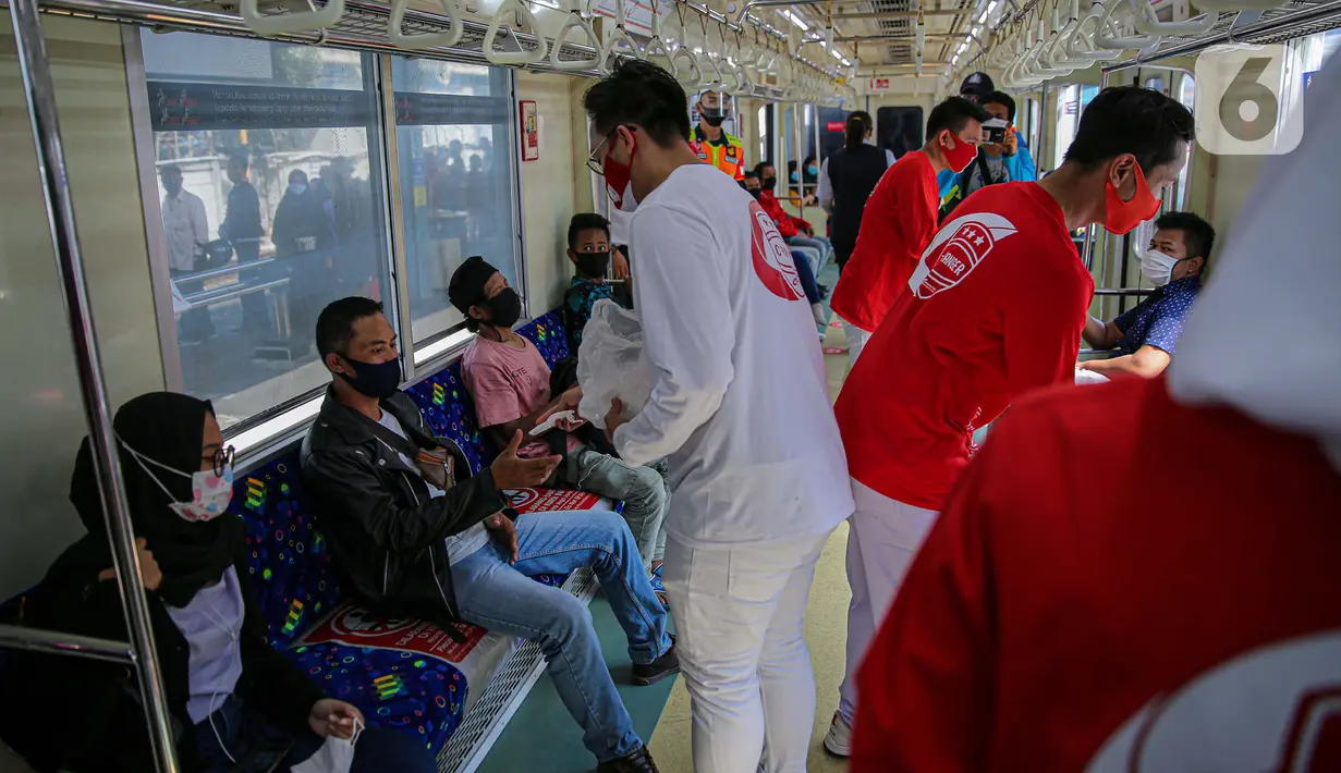Sekelompok milenial PT KCI bernama C-Ranger membagikan masker kepada para pengguna jasa KRL di Stasiun Tanah Abang, Jakarta, Senin (17/8/2020). PT Kereta Commuter Indonesia (KCI) memperingati Hari Kemerdekaan RI dengan membagikan masker kepada para pengguna jasa KRL. (Liputan6.com/Faizal Fanani)