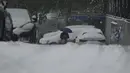 Seorang pria melintas di jalan saat salju turun di Beijing, China, Minggu (7/11/2021). Badai salju awal musim telah menyelimuti sebagian besar Cina utara termasuk ibu kota Beijing, mendorong penutupan jalan dan pembatalan penerbangan. (Noel Celis / AFP)