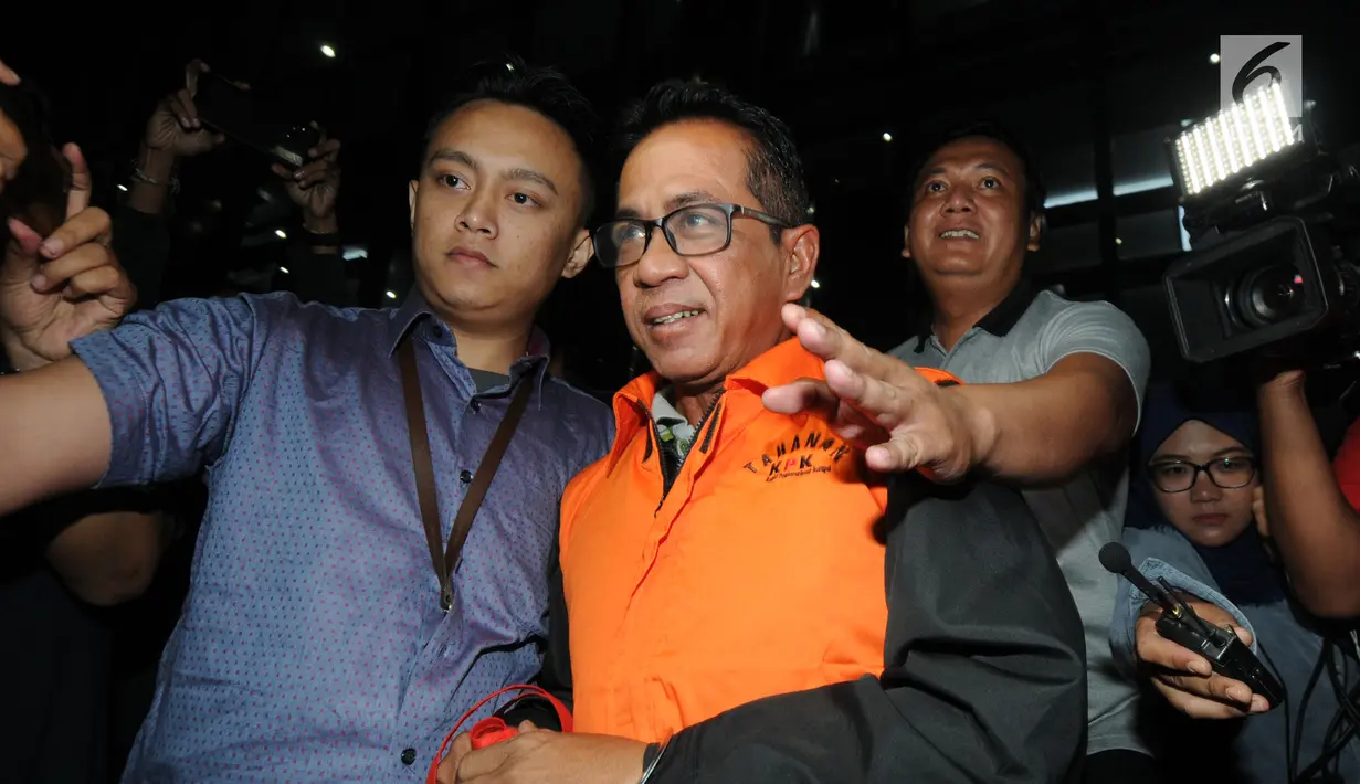 Bupati Mesuji, Khamami kenakan rompi tahanan dikawal petugas usai menjalani pemeriksaan 1x24 jam di gedung KPK, Jakarta, Jumat (25/1). Khamami terjaring OTT terkait fee suap proyek infrastruktur Kabupaten Mesuji. (merdeka.com/Dwi Narwoko)