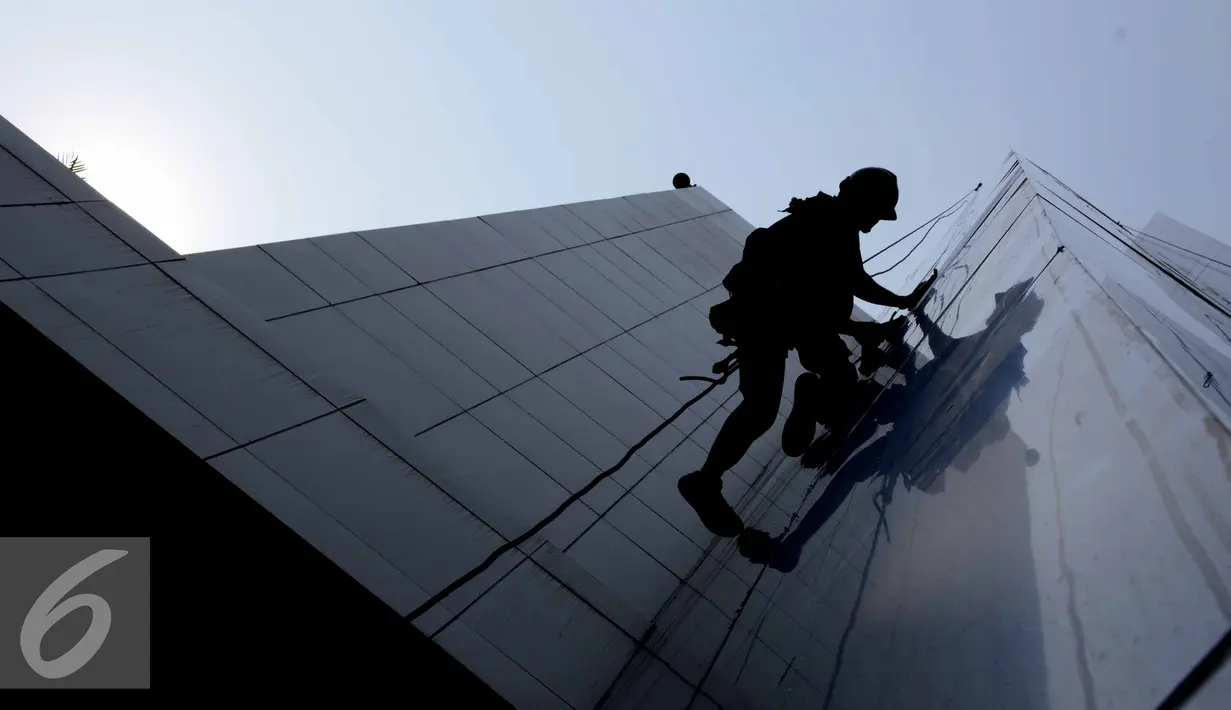 Pekerja membersihkan kaca gedung bertingkat di Jakarta, Senin (25/8/2015). Untuk meminimkan kecelakaan, Kementerian Tenaga Kerja dan Transmigrasi telah mencanangkan bulan Keselamatan dan Kesehatan Kerja (K3) pada tahun 2014. (Liputan6.com/Helmi Afandi)