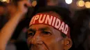 Seorang demonstran mengenakan ikat kepala yang bertuliskan "Impunity" saat berujuk rasa menuntut presiden Honduras,  Juan Hernandez untuk mundur atas dugaan korupsi senilai  US$ 200 juta di Tegucigalpa, Jumat (24/7/2015).  (REUTERS/Jorge Cabrera)