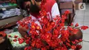 Pedagang saat membuat pohon bunga Meihua di salah satu toko Asemka, Glodok, Jakarta, Rabu (3/2/2021). Namun dimasa pandemi, penjualan bunga ini berkurang dikarenakan banyak pembeli yang lebih memilih pembelian online. (Liputan6.com/Johan Tallo)