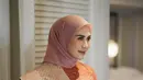 Sang istri, Syahnaz, tampil elegan dalam busana Baju Kurung berpotongan A-line yang memberikan kesan anggun sekaligus sederhana. Detail volume di bagian lengan menambahkan elemen dramatis tanpa mengurangi kesan modest yang diusung. Warna koral segar berpadu indah dengan songket beige berbenang koral, menciptakan tampilan mewah yang memancarkan nuansa cerah dan berkelas.  @wanda_haraa/@didietmaulana].