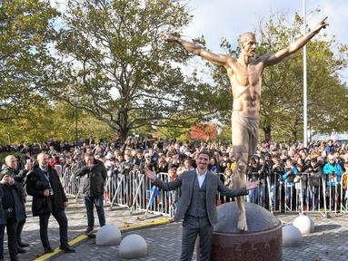 Bintang sepak bola Swedia Zlatan Ibrahimovic berpose dengan patung yang menyerupainya dekat Stadion Malmo, Malmo, Swedia, Selasa (8/10/2019). Ibrahimovic dikokohkan statusnya sebagai ikon Kota Malmo lewat sebuah patung. (Johan NILSSON/TT News Agency/AFP)