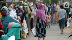 Antrean warga sekitar perumahan Villa Pamulang mengambil paket sembako gratis bernama “Jumat Berkah” yang digantung di Tangerang Selatan, Jumat (28/8/2020). Setiap Jumat selama pandemi, warga perumahan itu mendonasikan sembako untuk warga sekitar yang terdampak COVID-19. (merdeka.com/Dwi Narwoko)