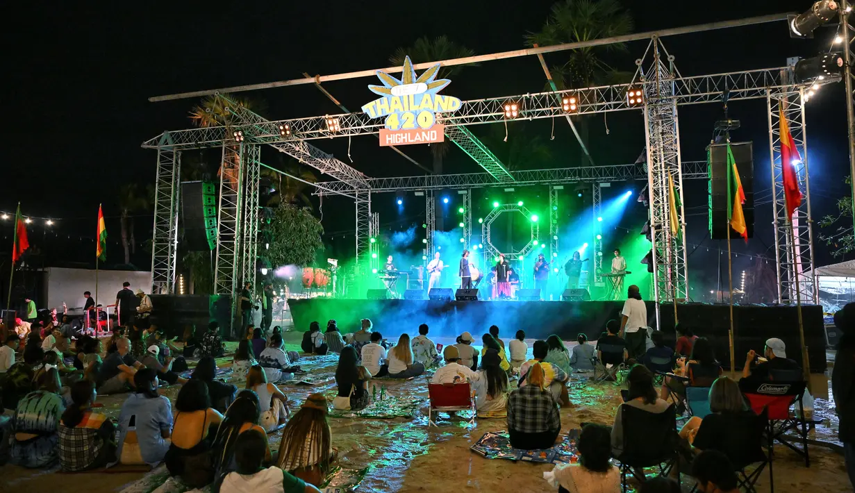 Orang-orang mendengarkan band saat mereka berkumpul untuk merayakan legalisasi ganja di “Thailand: 420 Legalaew!” festival akhir pekan yang diselenggarakan oleh Highland di provinsi Nakhon Pathom 11 Juni 2022. (AFP/Lillian Suwanrumpha)