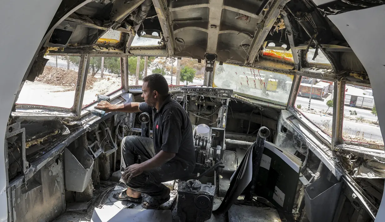 Teknisi mengebor lubang di kokpit pesawat Boeing 707 yang diubah oleh saudara kembar Palestina Atallah dan Khamis al-Sairafi menjadi sebuah restoran di kota Nablus, pada 5 Juli 2021. Meja akan segera dipasang di badan pesawat yang telah dicat putih dengan lantai kayu laminasi. (JAAFAR ASHTIYEH/AFP)