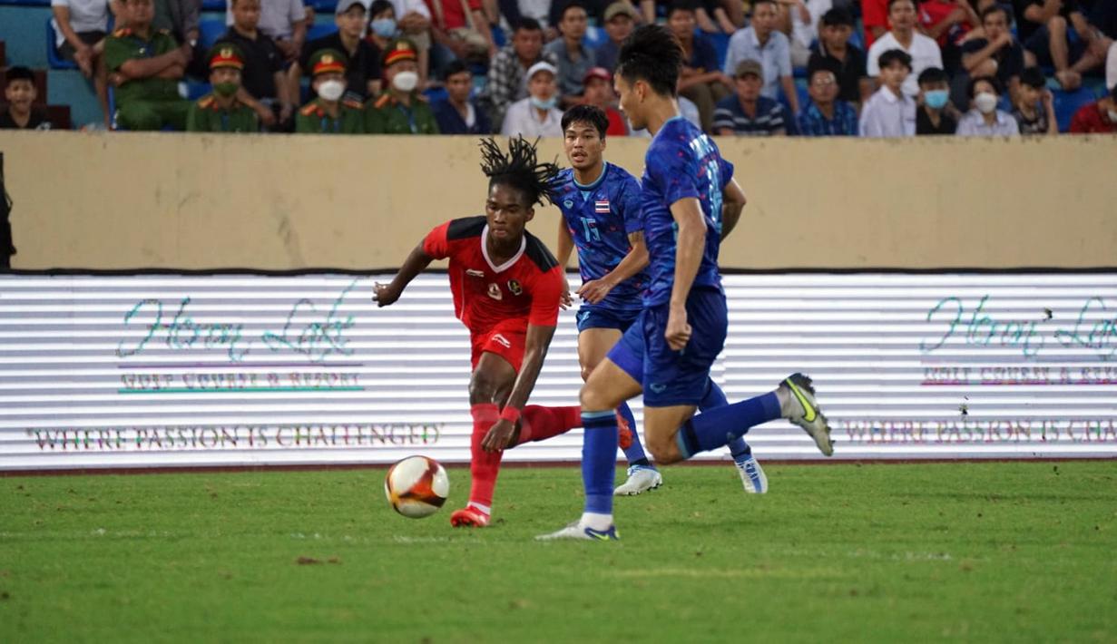 Pemain Timnas Indonesia U-23 Ronaldo Kwateh (kiri) menggiring bola melewati para pemain Timnas Thailand U-23 pada pertandingan semifinal SEA Games 2021 di Thien Truong Stadium, Vietnam, Kamis (19/5/2022). Timnas Indonesia U-23 kalah 0-1. (Dok. PSSI)