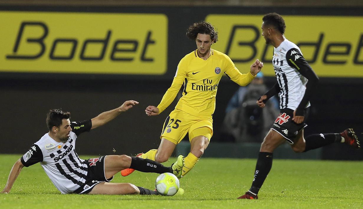 Aksi pemain PSG, Adrien Rabiot (tengah) melewati adangan pemain Angers, Thomas Mangani pada lanjutan Ligue 1 Prancis di Raymond Kopa Stadium, Angers, (4/11/2017). PSG menang telak 5-0. (AP/David Vincent)