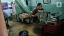 Warga bersih-bersih rumah usai terendam banjir di kawasan Kampung Melayu, Jakarta, Senin (8/11/2021). Warga belum mengungsi dan masih berharap air akan surut. (Liputan6.com/Faizal Fanani)