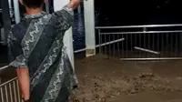 Seorang warga melintas di koridor rumah sakit Torabelo Sigi saat banjir memasuki rumah sakit, Kamis (9/7/2020). (Foto: Sreenshoot video banjir RS Torabelo).