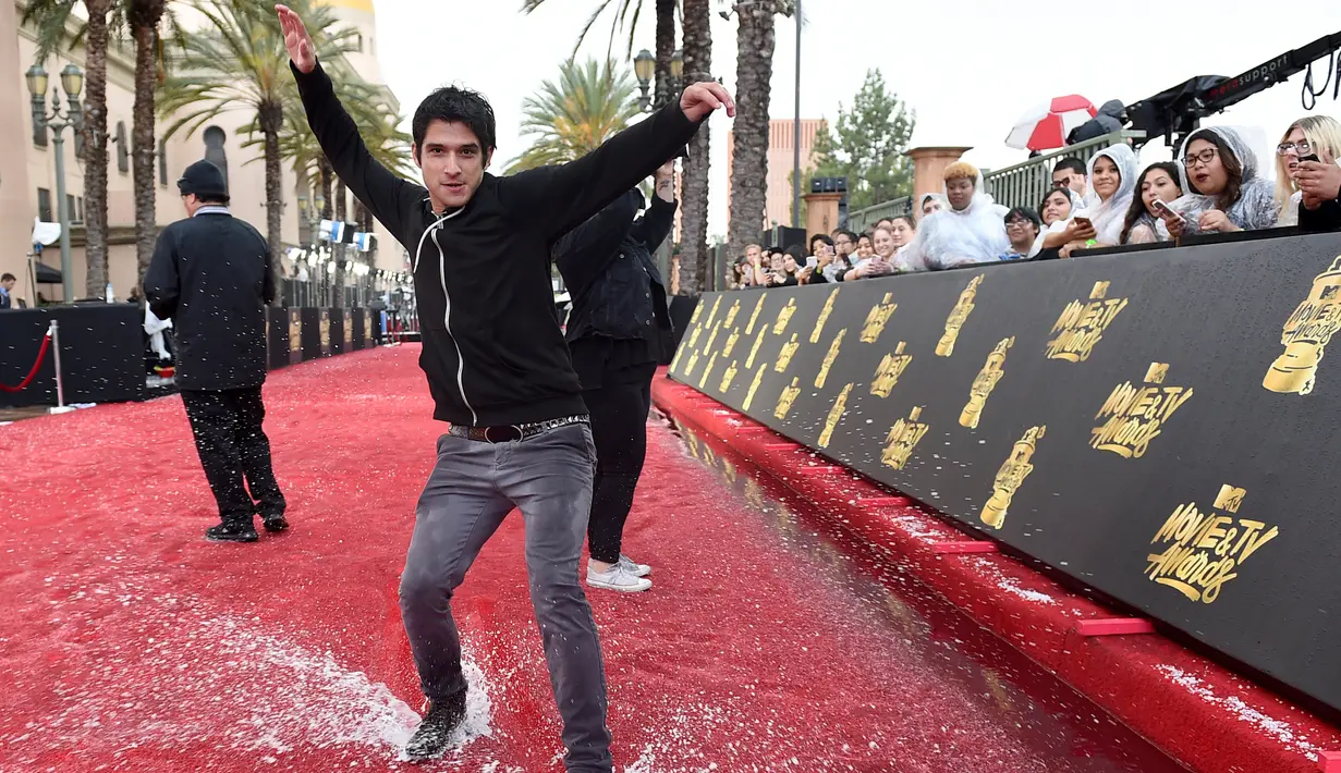 Aktor Aktor Tyler meluncur di atas karpet merah yang basah akibat hujan sebelum MTV Movie and TV Awards 2017 di Los Angeles, (7/5). (Photo by Jordan Strauss/Invision/AP)