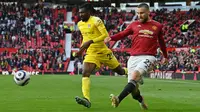 Bek Manchester United (MU), Luke Shaw mengoper bola di depan gelandang Fulham, Andre-Frank Zambo Anguissa (tengah) pada pekan 37 Liga Inggris di Stadion Old Trafford, Rabu (19/5/2021) dinihari WIB. MU kembali gagal menang setelah ditahan imbang 1-1 oleh tamunya Fulham. (Paul ELLIS/POOL/AFP)