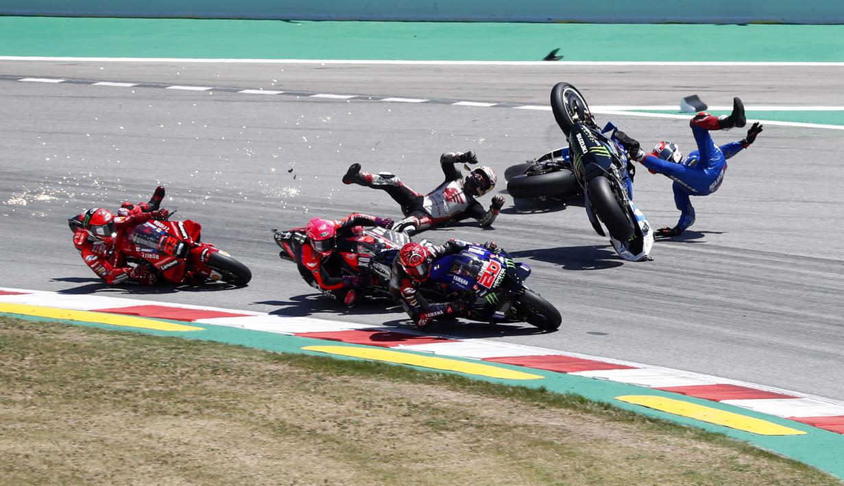 Motor Nakagami kemudian membentur Alex Rins (kanan). Pebalap Suzuki Ecstar itu akhirnya ikut jatuh dan sempat terpental ke udara. (AP/Joan Monfort)
