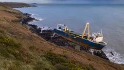 Kapal kargo sepanjang 77 meter, MV Alta,  terjebak di atas batu di dekat Ballycotton, Cork, Irlandia, Selasa (18/2/2020). "Kapal hantu" yang berlayar tanpa awak selama lebih dari satu tahun hanyut dan terbawa ke pantai selatan Irlandia menyusul sapuan Badai Dennis. (Cathal Noonan/AFP)